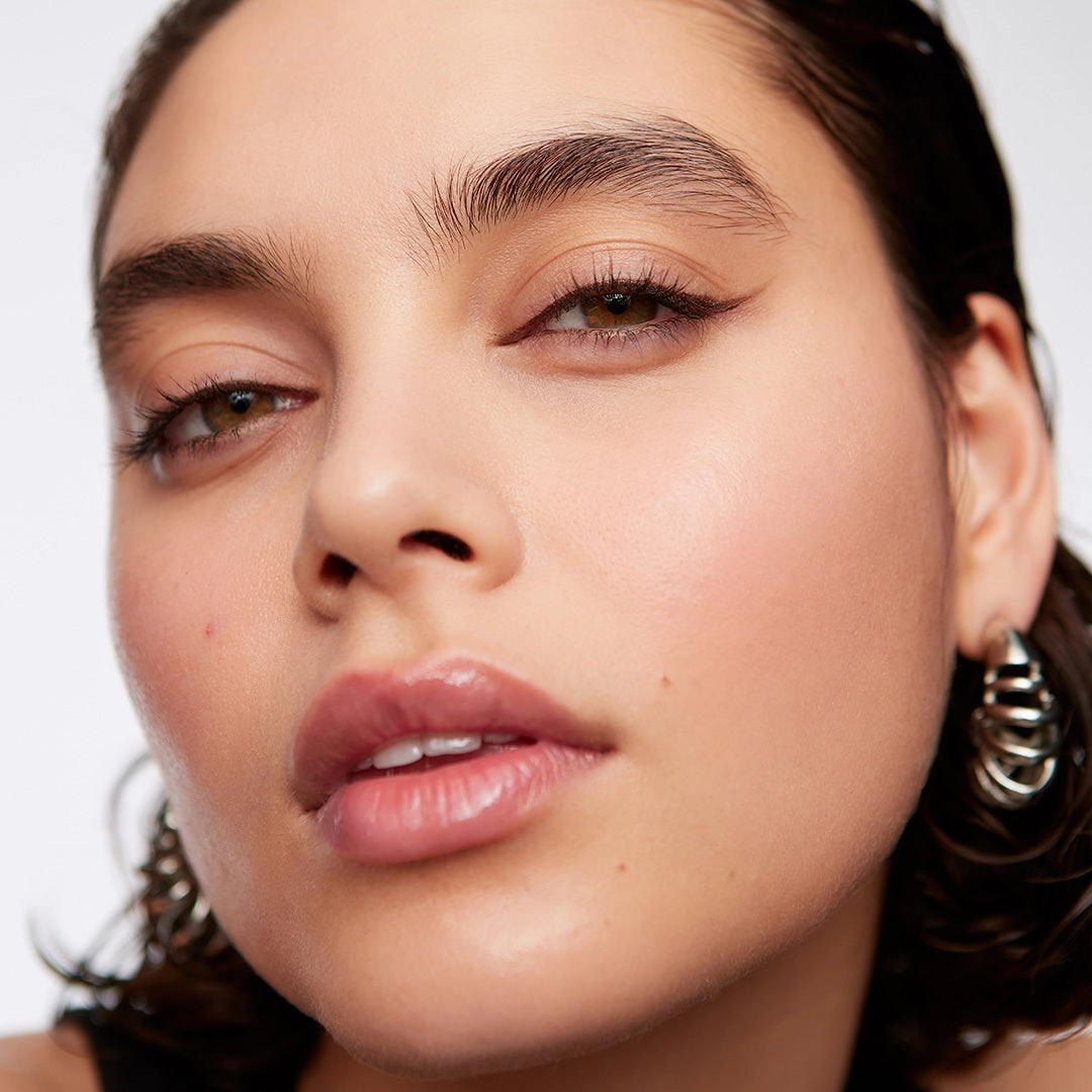 Woman with a brown bronze lip and hoop earrings