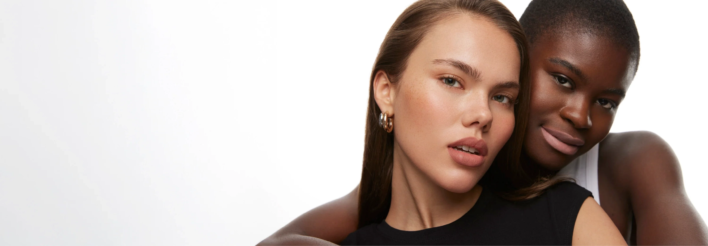 Two women with their faces close together against a white background
