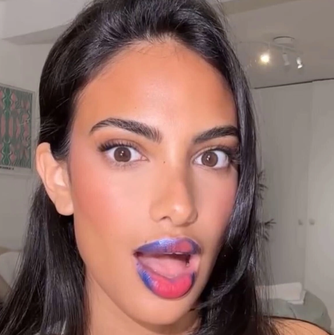 Woman showing off blue lip masque on her lips and tongue