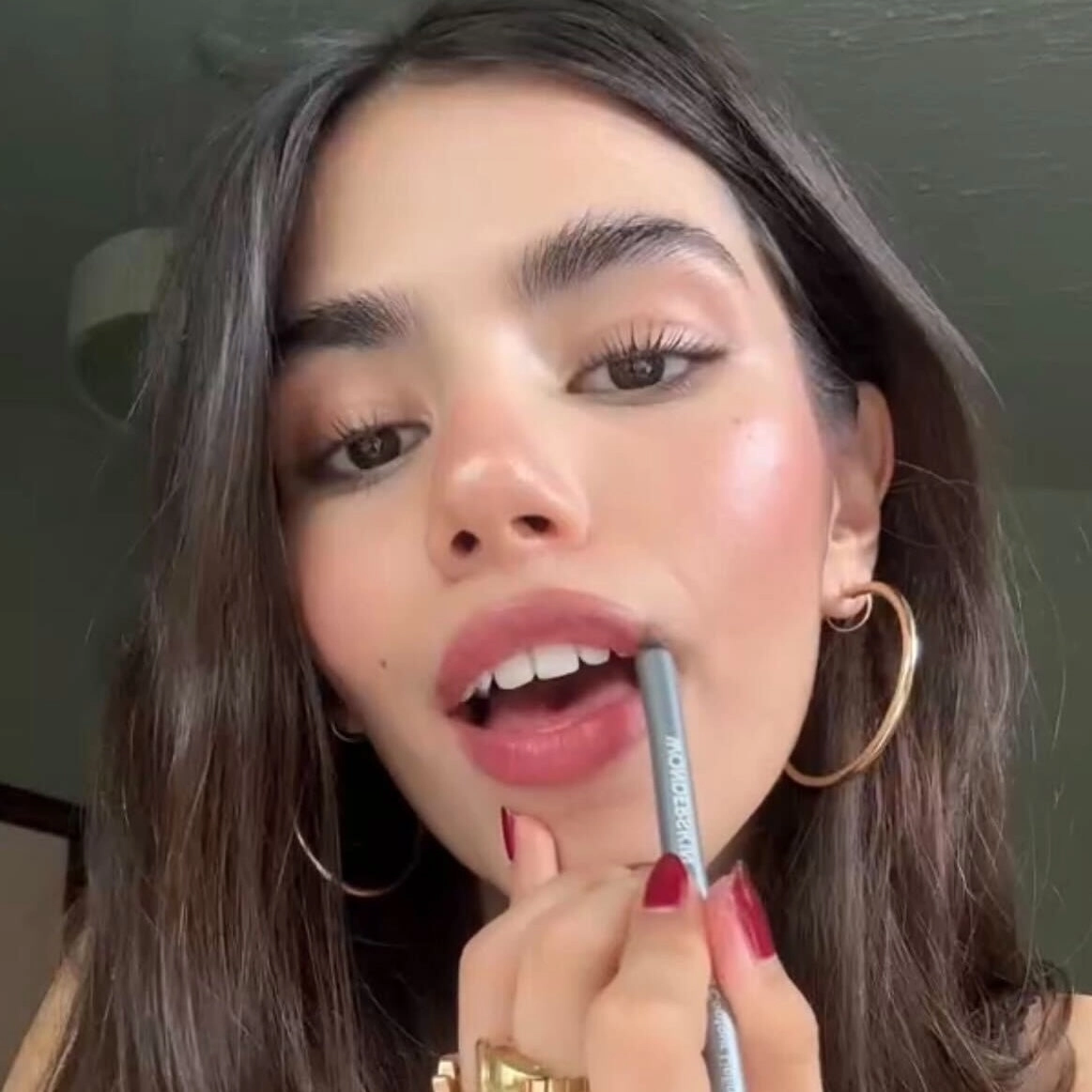 Woman lining her lips with a lip liner pencil