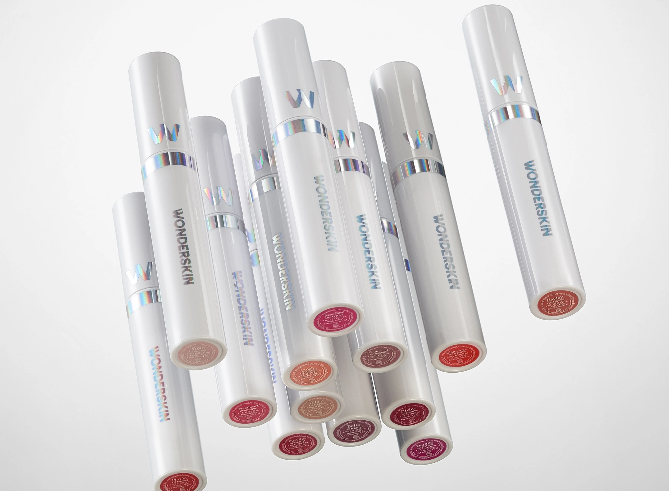 A scatter of white lip stain tubes with colored caps